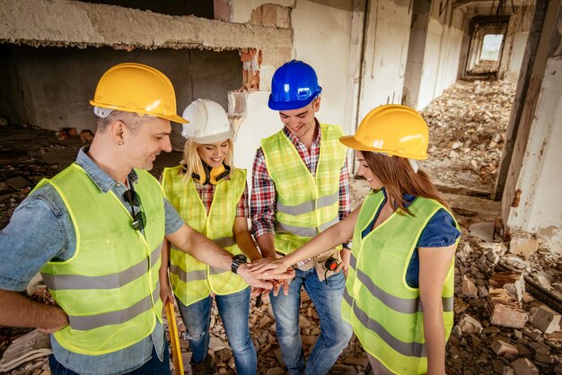 Cuatro arquitectos de construcción en edificios dañados en el desastre con las manos dobladas, motivando nuevas victorias comerciales.