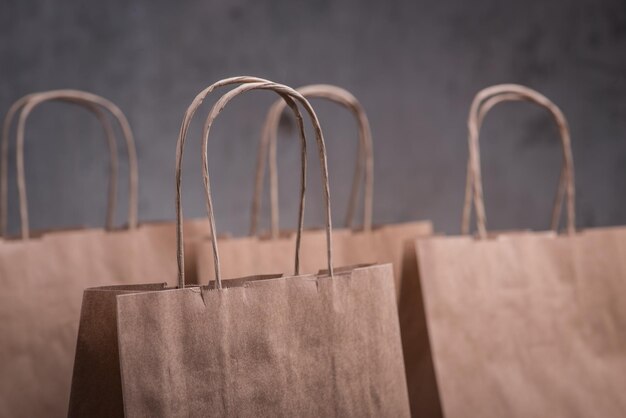 Cuatro bolsas de papel artesanales sobre el fondo gris