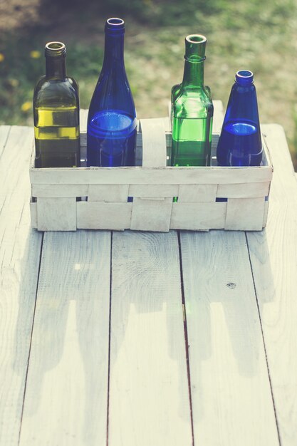 Cuatro botellas de bebidas en una canasta blanca sobre la mesa blanca