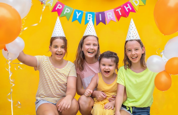 Foto cuatro chicas con pelotas sobre un fondo amarillo. niños en la fiesta