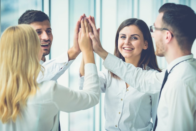 Los cuatro empresarios felices saludando con un choca esos cinco