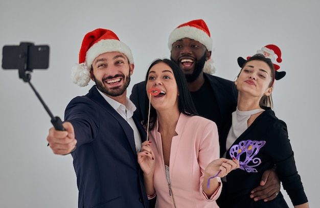 Los cuatro empresarios felices con sombrero rojo haciendo selfie