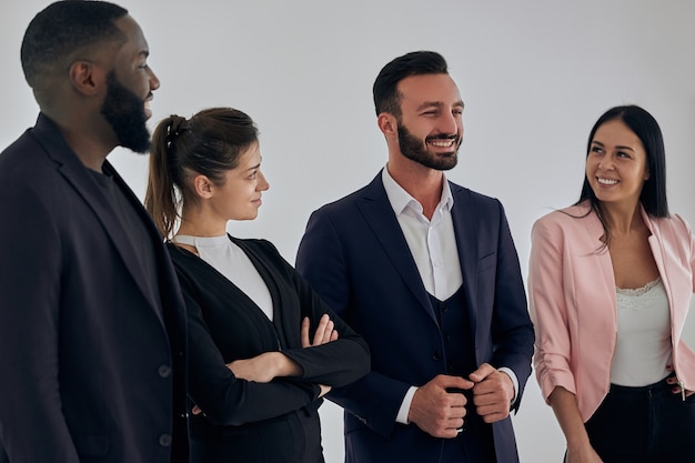 Los cuatro empresarios internacionales de pie junto a la pared.