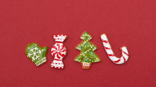 Cuatro galletas de Navidad sobre un fondo rojo.