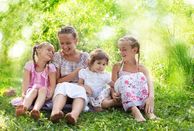 Cuatro hermosas chicas sentadas en el césped del jardín y sonriendo