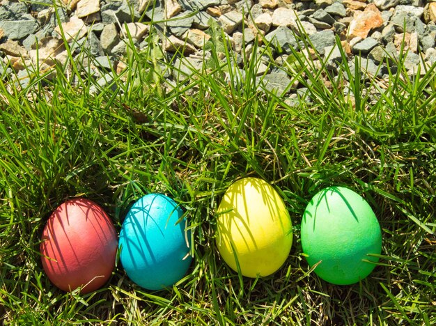 Cuatro huevos de Pascua pintados y decorativos en la hierba. Vista superior, espacio de copia