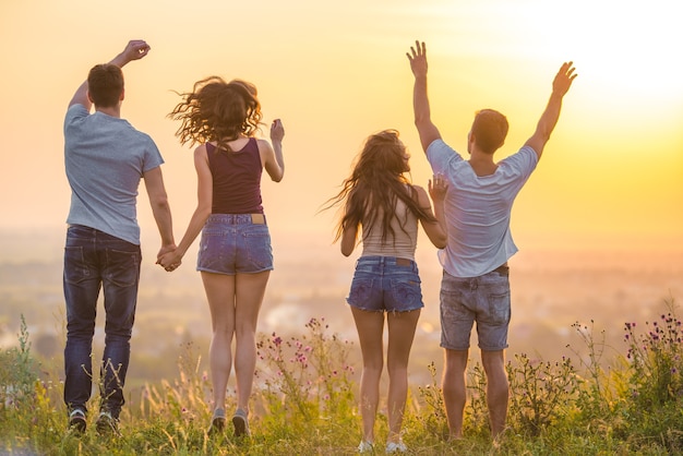 Los cuatro jóvenes saltando sobre la hierba