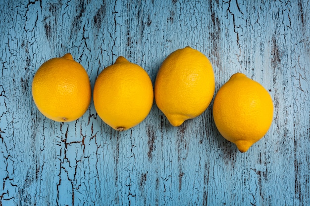 Cuatro limones en mesa azul