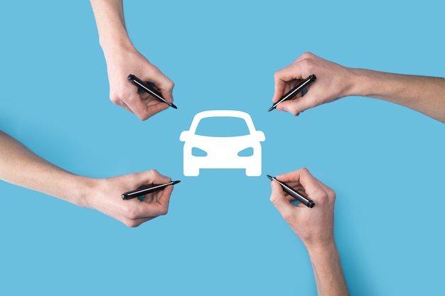 cuatro manos dibujan un icono de coche con un marcador.