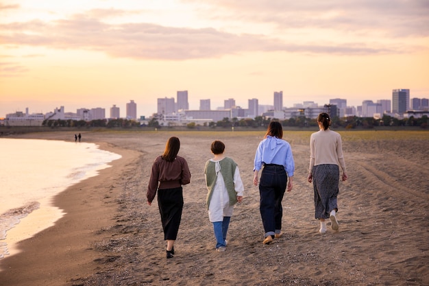 Cuatro mujeres jóvenes caminando por el mar al atardecer