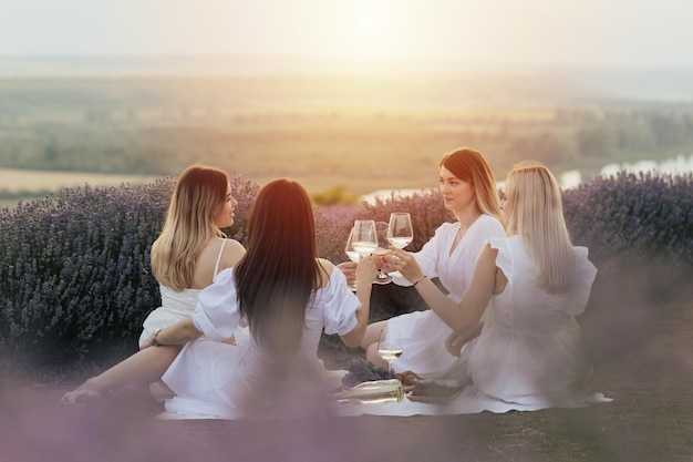 Cuatro mujeres sentadas sobre una manta en un campo de lavanda