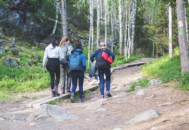 Cuatro niñas caminando por un sendero en el bosque