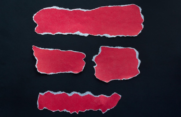 cuatro pedazos de papel rojo sobre un fondo negro