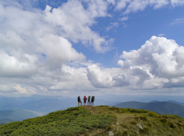 Las cuatro personas activas de pie en la pintoresca montaña