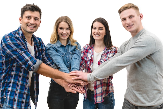 Las cuatro personas felices se dan la mano sobre el fondo blanco.