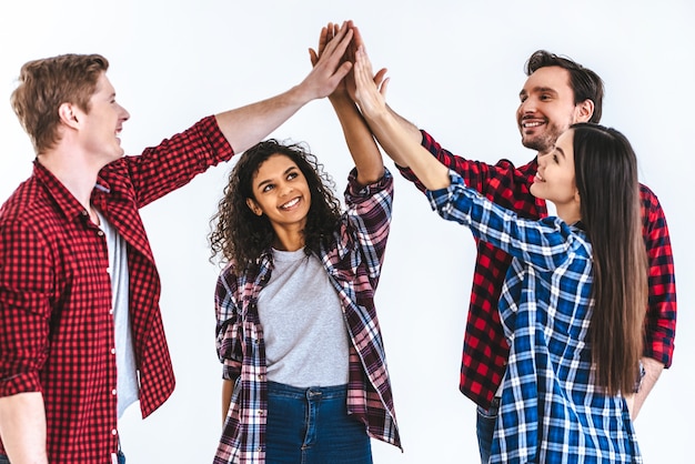 Foto las cuatro personas felices saludando en el fondo de la pared blanca