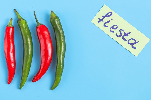 Cuatro piezas de chiles rojos y verdes picantes con una nota amarilla de fiesta en un azul claro