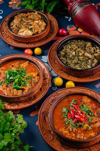Cuatro platos georgianos servidos en una mesa con cilantro y ciruela