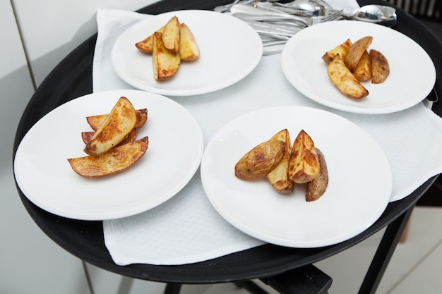 Cuatro platos con rodajas de deliciosas patatas fritas.