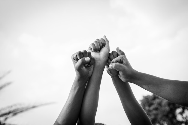 Cuatro puños de africanos levantados al cielo foto en blanco y negro con espacio de copia