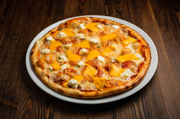 Cuatro tipos de pizza de queso, fondo de madera, bajo perfil