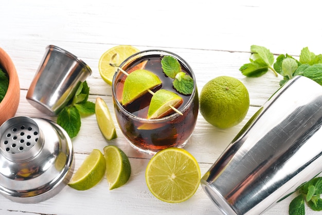 Cuba Libre Cocktailglas Kalkminze auf weißem Holzhintergrund Freier Platz für Text