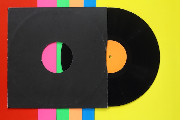 Cubierta de papel negro envejecido y disco LP de vinilo azul aislado sobre fondo colorido