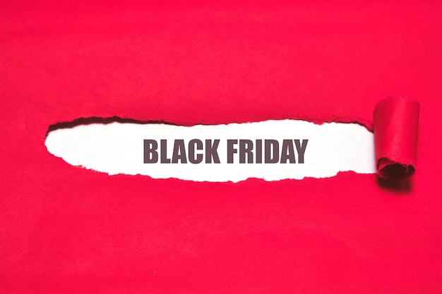 Cubierta roja rasgada y fondo blanco con las palabras viernes negro. Publicidad del día mundial de la venta.