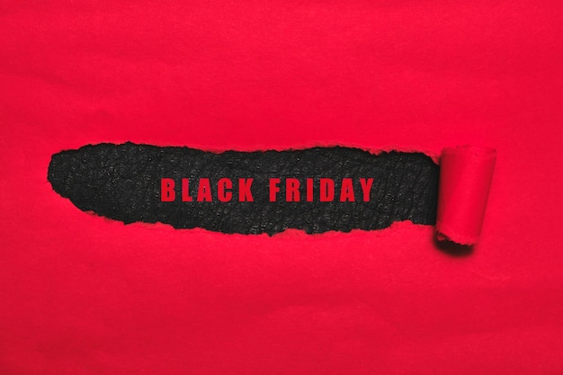 Cubierta roja rasgada y fondo negro con las palabras viernes negro. Publicidad del día mundial de la venta.