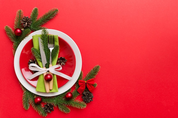 Cubierto de mesa de Navidad con decoración navideña y platos, vacas, tenedor y cuchara. Fondo de vacaciones de Navidad. Vista superior con espacio de copia.