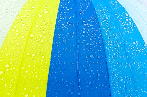 Cubierto con pequeñas y grandes gotas de agua, un paraguas de calidad que protege de las precipitaciones, la lluvia exterior.