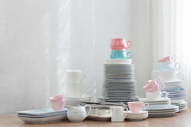 Cubiertos de color rosa, blanco y azul sobre una mesa de madera contra una pared blanca