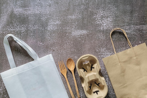 Cubiertos de madera del bolso de la compra de comestibles del papel de Kraft marrón en el piso de cemento Eco alternativo libre del plástico