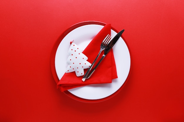 Cubiertos de mesa navideña con platos rojos y blancos