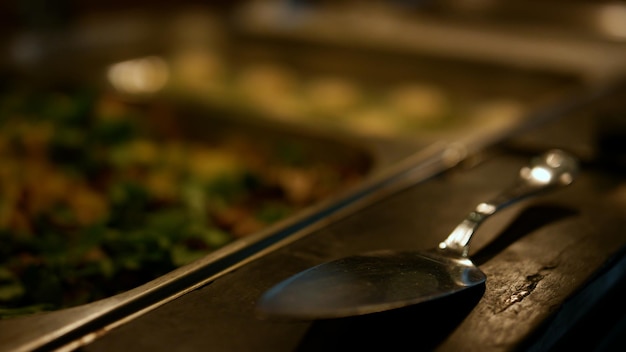 Cubiertos de plata servidos en una cena buffet orgánica en un restaurante de hotel oscuro cerrado