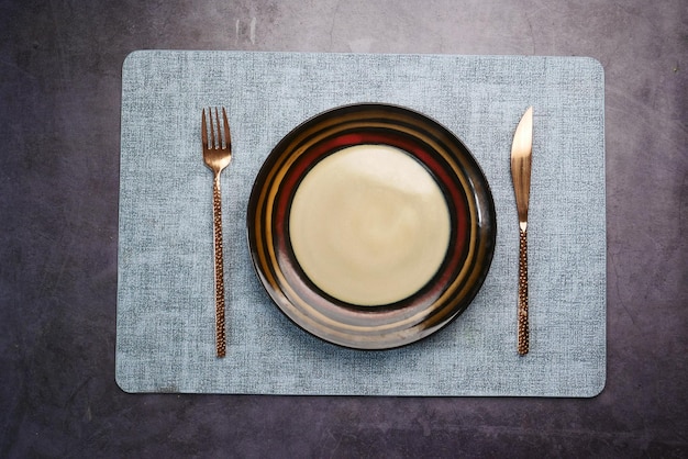 Cubiertos y plato vacío sobre fondo de madera de arriba hacia abajo