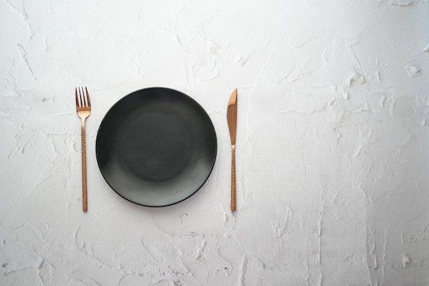 Cubiertos y plato vacío sobre fondo de madera de arriba hacia abajo