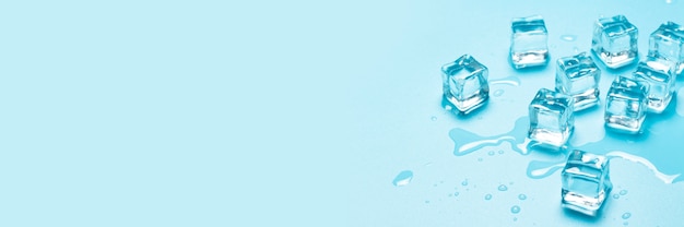 Cubitos de hielo con agua sobre un fondo azul. Concepto de hielo para bebidas. Bandera