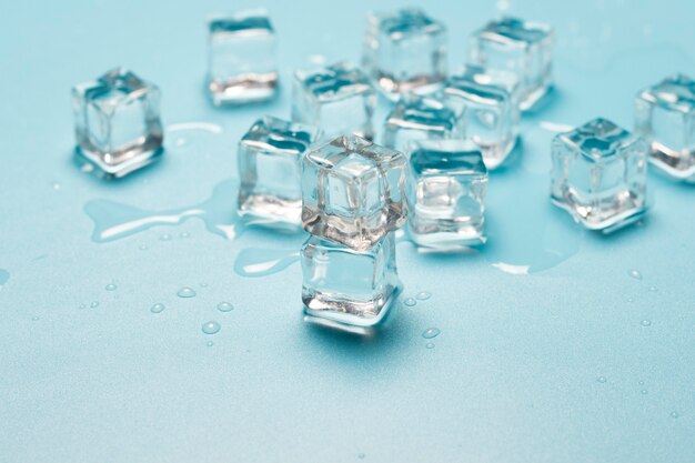 Cubitos de hielo con agua sobre un fondo azul. Concepto de hielo para bebidas.