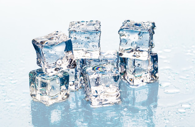 Cubitos de hielo derretidos cuadrados en mesa húmeda