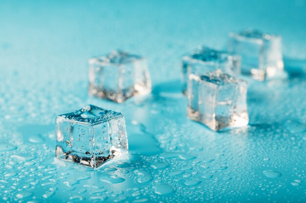 Los cubitos de hielo están dispersos con gotas de agua dispersas. De cerca.