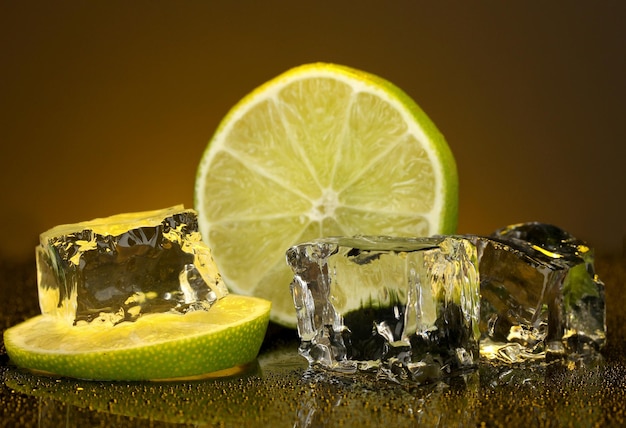 Cubitos de hielo con limón sobre fondo naranja oscuro