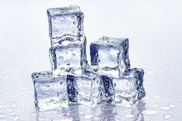Foto cubitos de hielo sobre fondo azul.