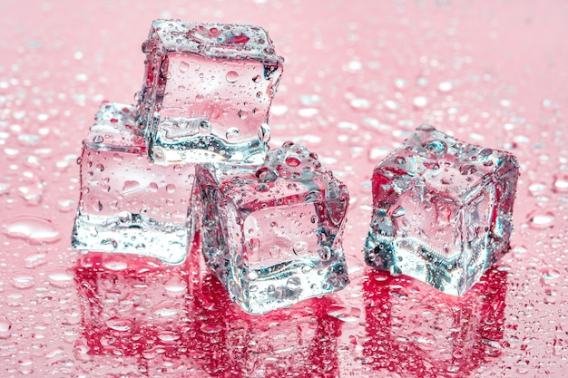 Cubitos de hielo sobre fondo rosa