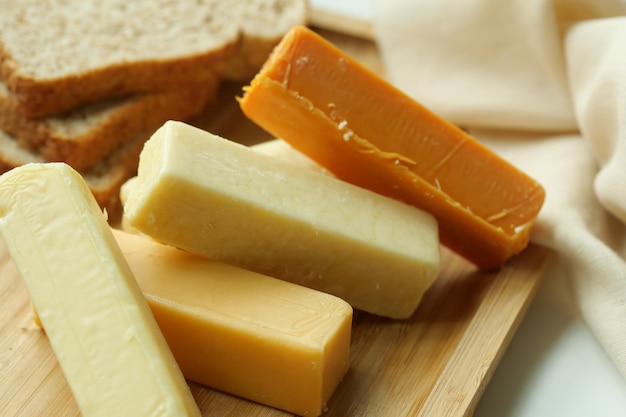 Cubitos de queso de color verde amarillo y rojo en una tabla de cortar