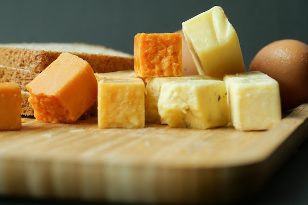 Cubitos de queso de color verde amarillo y rojo en una tabla de cortar
