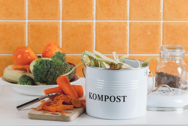 Cubo de basura para compostaje con restos en la cocina