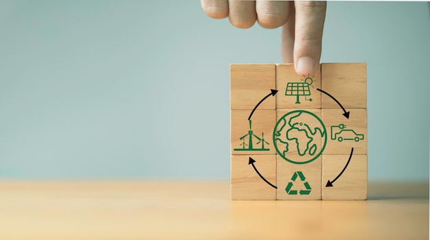 Cubo de bloque de madera en mano con flecha circular icono ambiental y de la tierra para la economía circular hacia el desarrollo sostenible crecimiento del negocio obtención de ganancias y concepto de reserva del medio ambiente