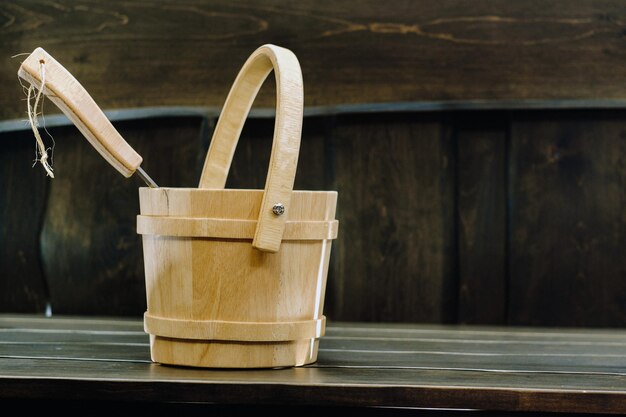 Cubo y cucharón en una sauna de madera. Accesorios de madera en la sauna.