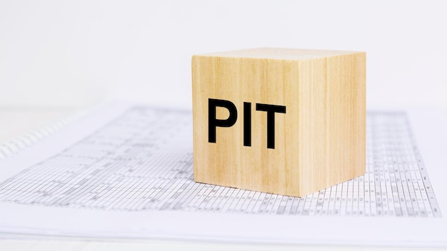 Cubo de madeira com as letras PIT conceito de imposto de renda pessoal
